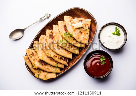 Aloo Paratha / Indian Potato stuffed Flatbread. Served with fresh curd and tomato ketchup. selective focus Royalty-Free Stock Photo #1211150911