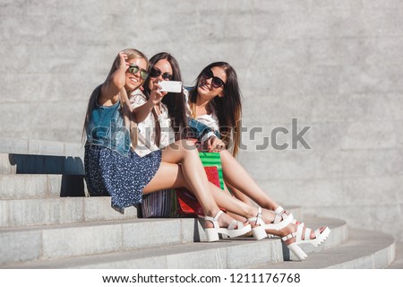 Attractive young women shopping. Beautiful ladies with shopping bags