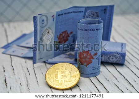Physical version of Bitcoin (new virtual money) and banknotes. Exchange bitcoin for banknotes. Conceptual image for worldwide cryptocurrency and digital payment system.