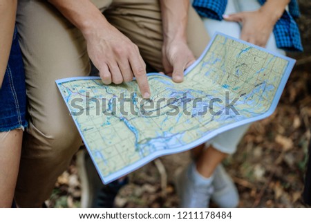 Group of friends watching the route in the traveler map on hiking