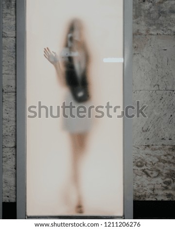 Faded woman silhouette behind the frozen glass door