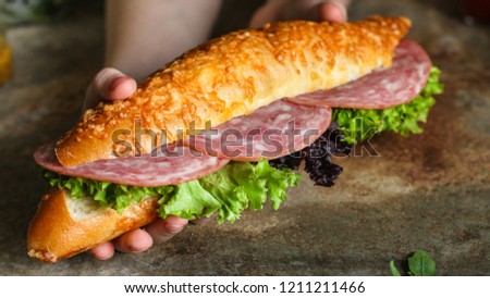 sandwich with bread rolls, lettuce, sausage ham on wooden background. Picnic food. top view
