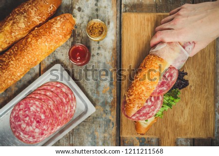 sandwich with bread rolls, lettuce, sausage ham on wooden background. Picnic food. top view
