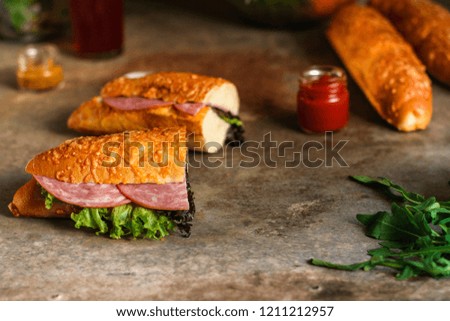 sandwich with bread rolls, lettuce, sausage ham on wooden background. Picnic food. top view