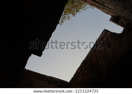 Ancient style Thai architecture with masonry, and a light hole from above as skylight for copy space using as background banner. way out, success and achievement and also traditional heritage tourism