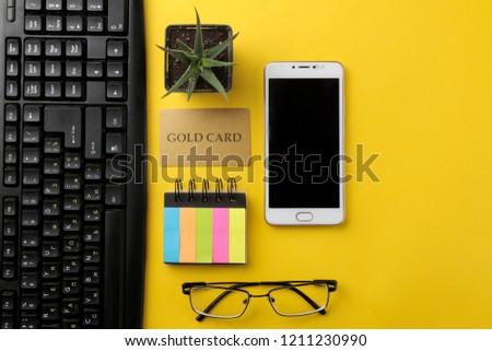 The concept of online shopping. Composition with a discount card and phone on a yellow background