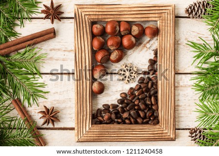 Christmas decoration with photo frame, decorative branches, presents,   nuts and cinnamon sticks. New Year and Christmas celebration. Holiday Greeting Card Design. 