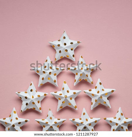 White and gold star decorations on a pastel pink. Seasonal festive background