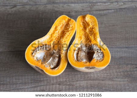 Pumpkin cut in half, pumpkin with seeds. Autumn vegetables. Recipe with pumpkin ingredient. Pumpkin on wooden background.