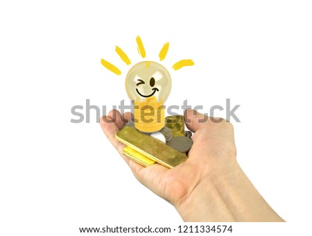 Light bulb or lamp toy yellow emoticons smile,gold and silver coins on hand isolated on white background.Concept Business idea to make money.