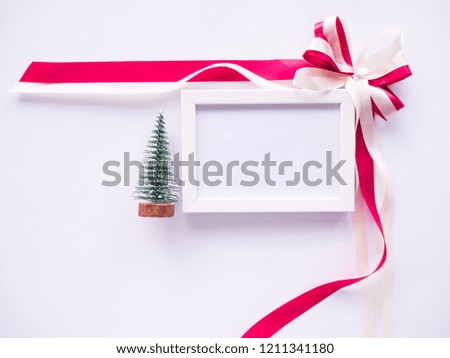 Flat lay of Picture frame with christmas tree and ribbon with blank space for text.