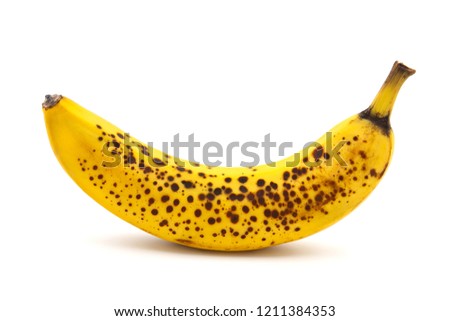 Banana with dark spots with shadow isolated on white background. Closeup, selective focus Royalty-Free Stock Photo #1211384353
