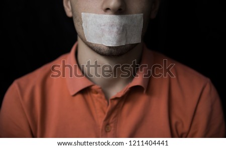 Man is silenced with adhesive tape on his mouth. Royalty-Free Stock Photo #1211404441
