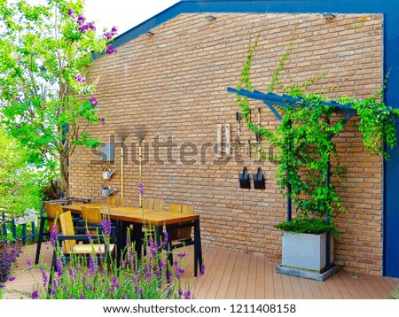 Wall for gardening tools. Table for gardening preparation. Garden sitting for tea. Gardening area in country style. Gardening in terrace.