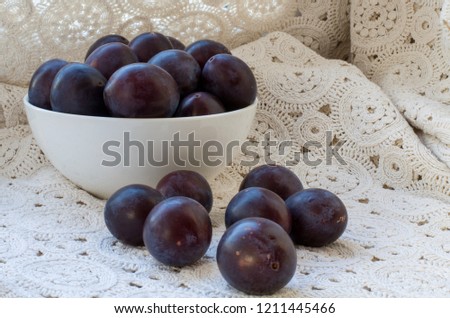 Ripe plum on a lace tablecloth