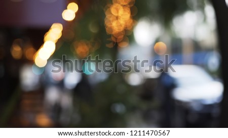 Bokeh shot of seating area outside restaurant of cafe with decorative lights