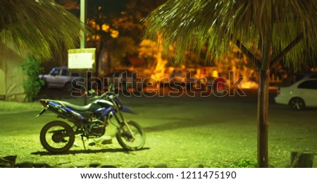 Defocused backdrop of parked motorcycle on Costa Rica street at night