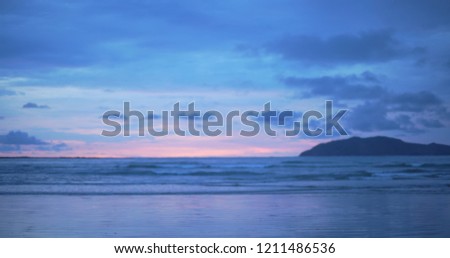 Out of focus background plate of beautiful purple and blue sunset on the beach