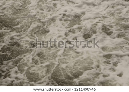 filled frame full screen desktop wallpaper background shot of greenish troubled wavy sea water  surface with white foam