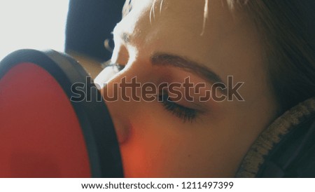 Eyes of female singer singing in sound studio. Beautiful girl recording new song. Working of creative musician. Show business concept. Slow motion Close up.