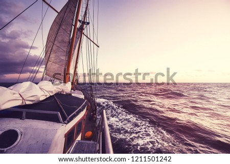 Old sailing ship at sunset, travel and adventure concept, color toned picture.