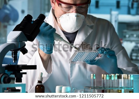 scientist working with microplate in a pharmaceutical lab / biomedical engineer working with samples in microplate in the laboratory Royalty-Free Stock Photo #1211505772