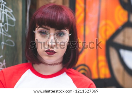 Portrait of woman with ginger hair, glasses and baseball T shirt