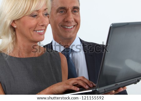 Smiling business professionals looking at a laptop