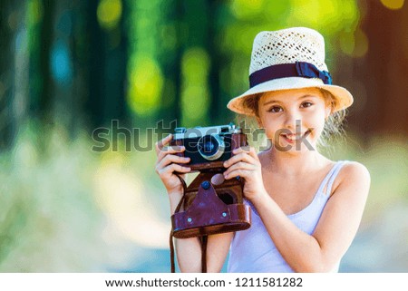 portrait of the beautiful girl with camera on the countryside road