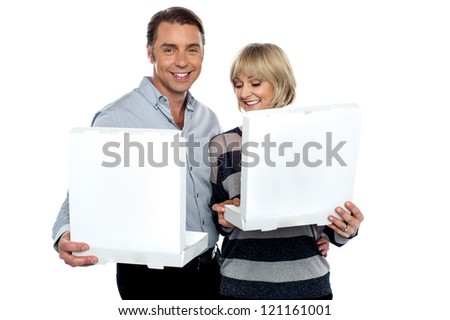 Lovely middle aged couple about to enjoy their meal. Holding white pizza boxes.