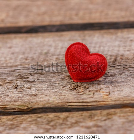 a beautiful red heart lies on a wooden background.