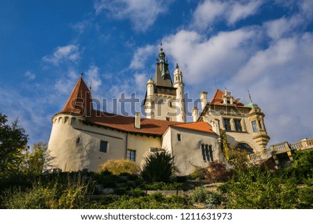 Famous romantic Pruhonice castle, Czech Republic, Europe, standing on hill in a park, sunny fall day, blue sky, white clouds, green foreground, bright colors