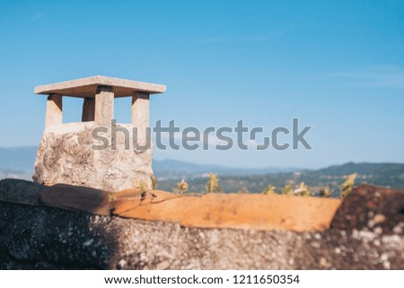 Stone chimney on a tiled roof