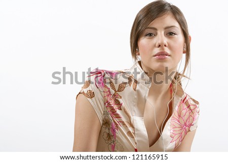 Beauty portrait of a young hispanic woman listening to music with her ear phones, isolated against a white background.