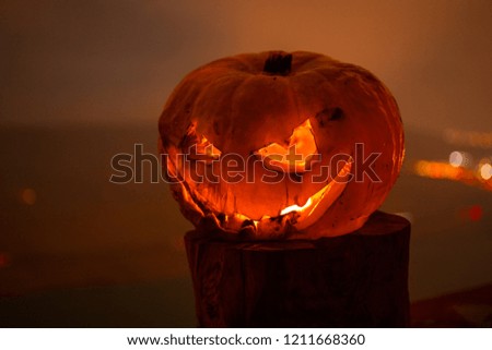 Horror Halloween concept. Close up view of scary dead Halloween pumpkin glowing at dark background. Selective focus