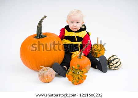 Baby with colorful pumpkins on white background                     