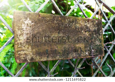 wooden sign board hanging on steel fence