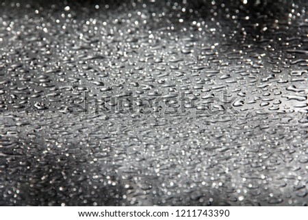 Blurred image with heavy raindrops or water drop on the smooth floor texture at night background .