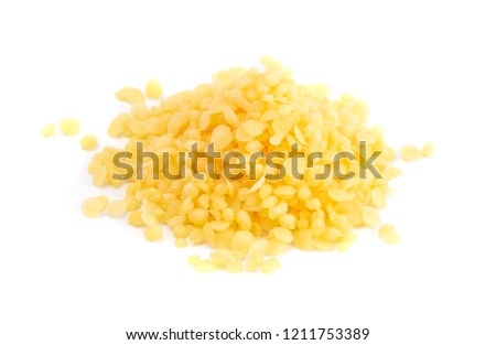 A Pile of Natural Yellow Beeswax Pearls on a Wax Background Royalty-Free Stock Photo #1211753389