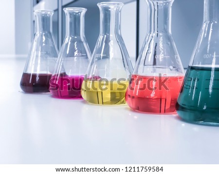 The Erlenmeyer or Conical flask on bench laboratory, with colorful solvent solution from titration experiment, acidity, alkalinity, and total hardness analysis compounding in wastewater sample. Royalty-Free Stock Photo #1211759584