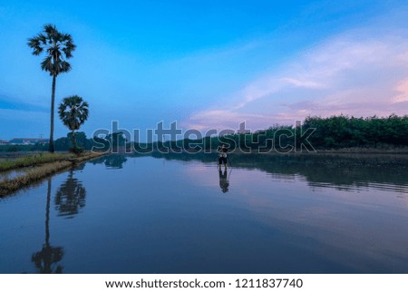 Photographer is taking a picture of sunrise with beautiful sky reflections