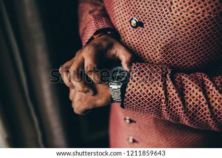 Indian groom getting ready and looking hand watches Royalty-Free Stock Photo #1211859643