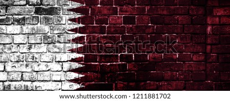 National flag of Qatar on a brick background. Concept image for Qatar: language , people and culture.