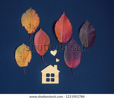 autumn card with wooden house and autumn leaves on dark  background/housewarming/anti-season depression