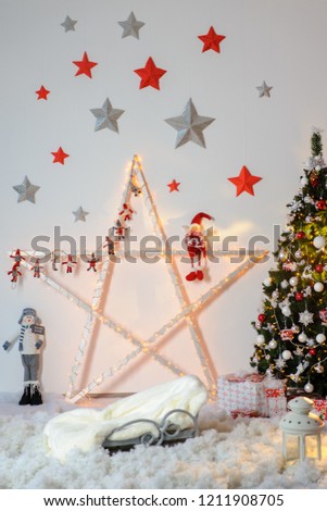 A large Christmas star decorated with festoons and various figures.