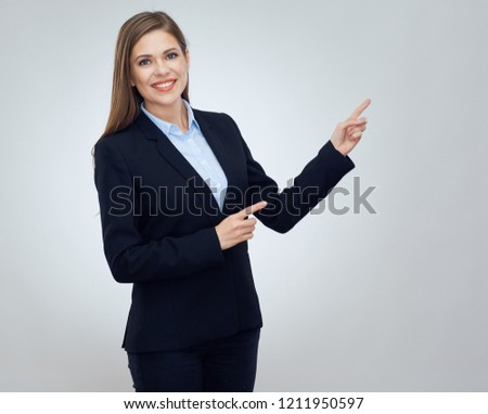 Business woman wearing black suit pointing finger at copy space. Isolated studio portrait.