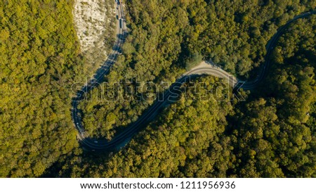 Directly above view of cars on a curvy road. Aerial drone shoot in the mountains.