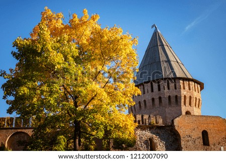 Golden autumn and bright colorful foliage, Park and a beautiful Park with trees in Sunny weather near the ancient stone fortress wall, a protective structure architectural landmark, tourism in autumn
