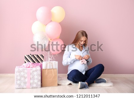 Beautiful pregnant woman with baby shower gifts near color wall Royalty-Free Stock Photo #1212011347