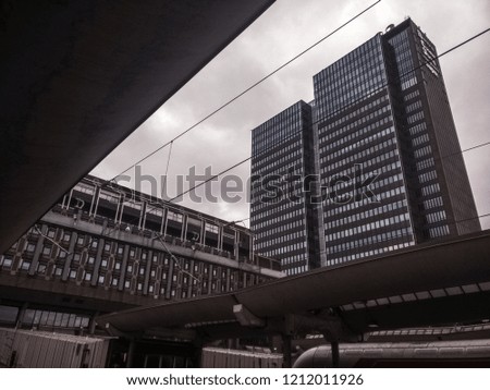 High buildings next to the train station of Oslo in Norway under a grey sky. Depressive mood.